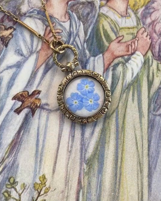 Forget-me-nots. In an antique gilt locket pendant