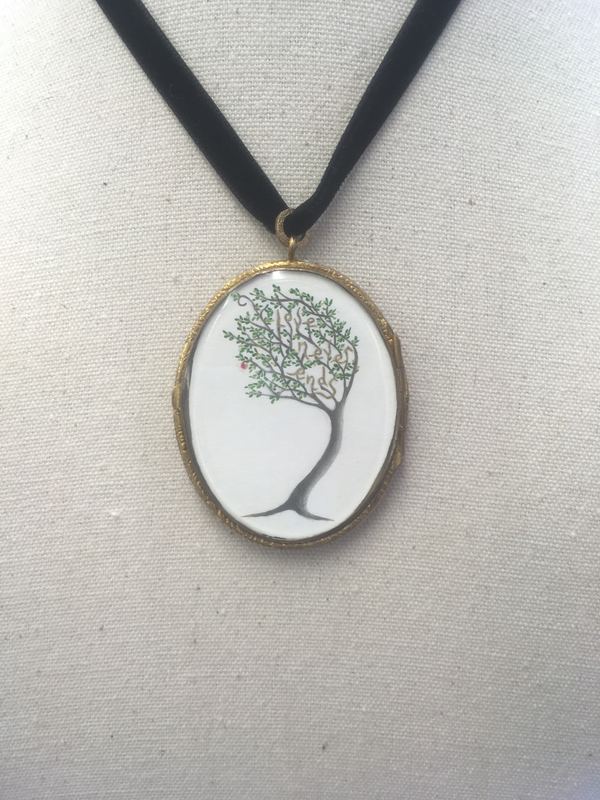 Love never ends. A tree in an oval locket on a velvet ribbon