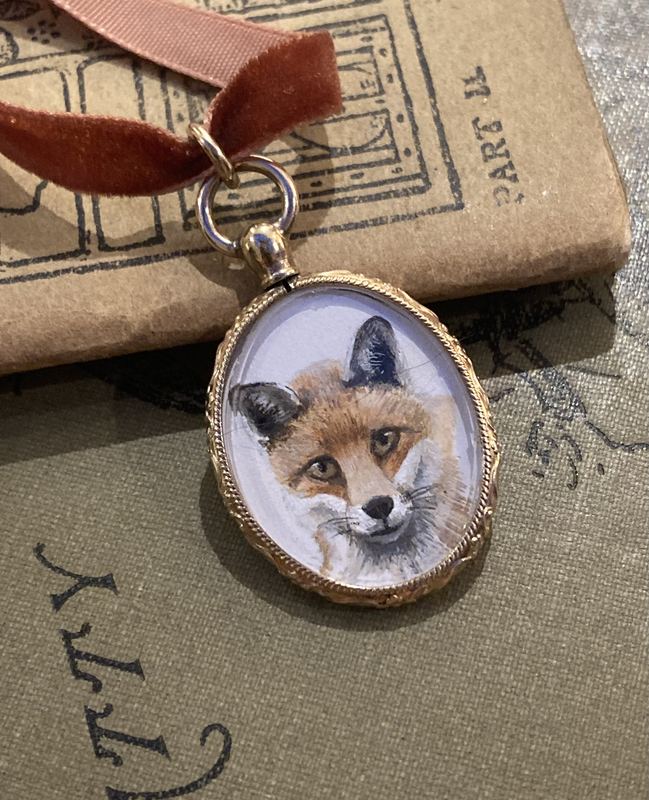 Mr Fox. In an oval locket on a velvet ribbon