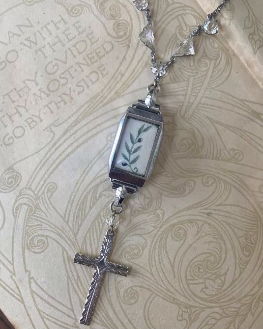 Olive branch. An Art Deco watch bezel with a silver cross