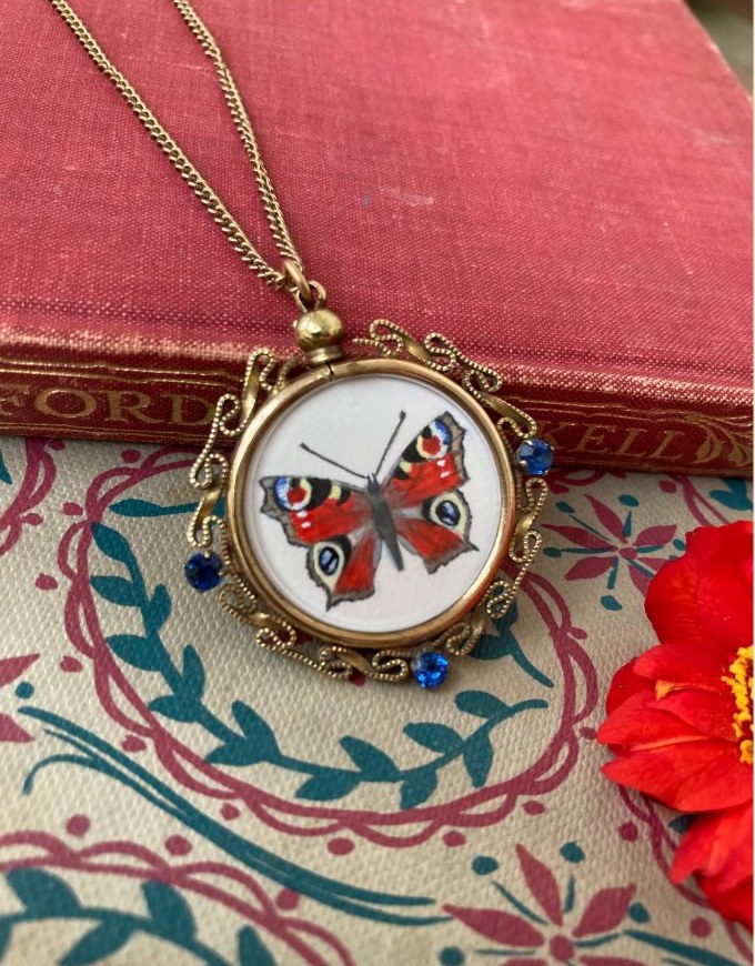Peacock butterfly. In a vintage sapphire paste locket