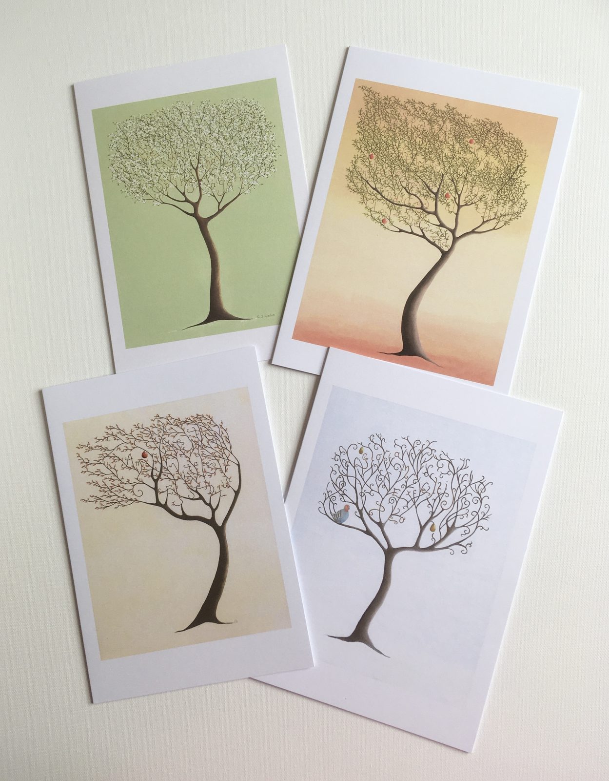 Four greetings cards, each printed with a tree in a different season